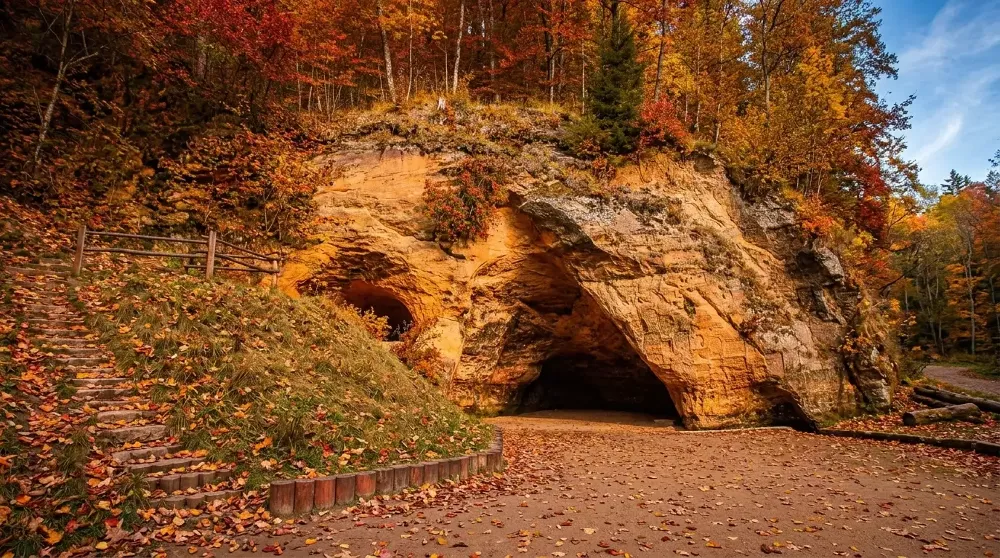 Gutmanis Cave – the largest sandstone cave in the Baltics, surrounded by golden autumn leaves