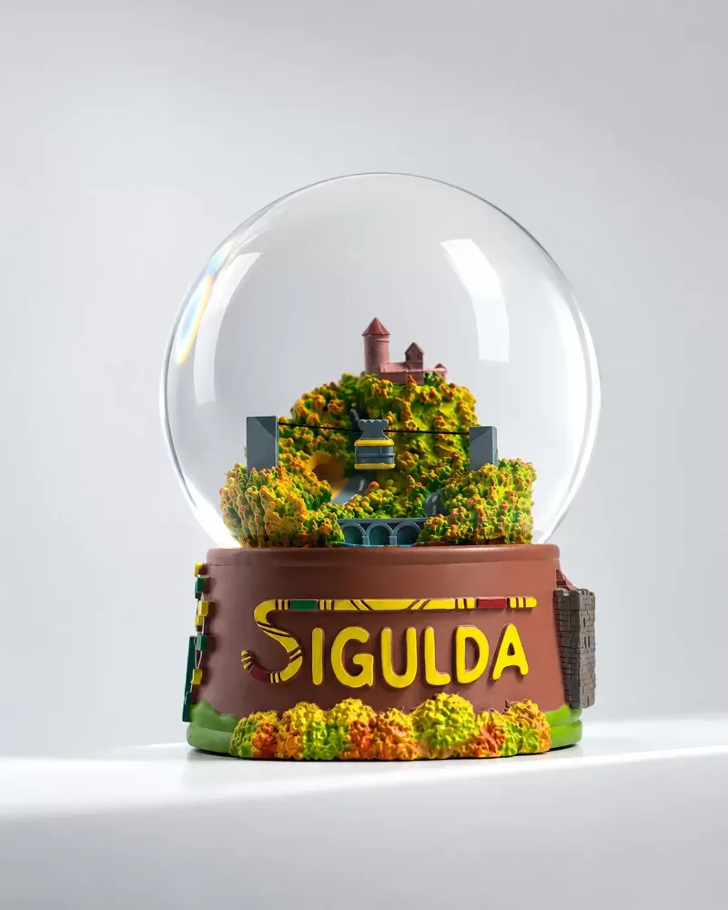 Sigulda Autumn Globe – a souvenir snow globe with the Sigulda landscape in golden autumn colours on a base with the word SIGULDA